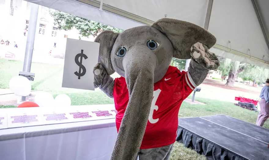 Big Al holding a dollar sign